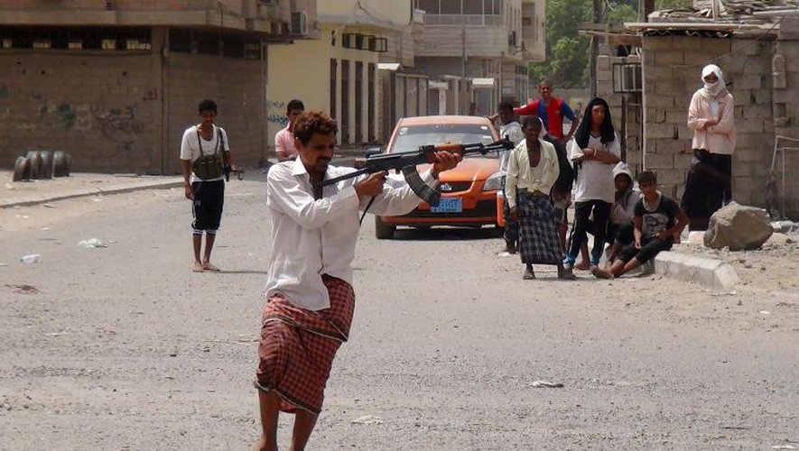 Des combattants yéménites partisans du président Abd Rabbo Mansour Hadi tirent en direction de rebelles chiites Houthis dans une rue d'Aden, dans le sud du pays, le 8 avril 2015