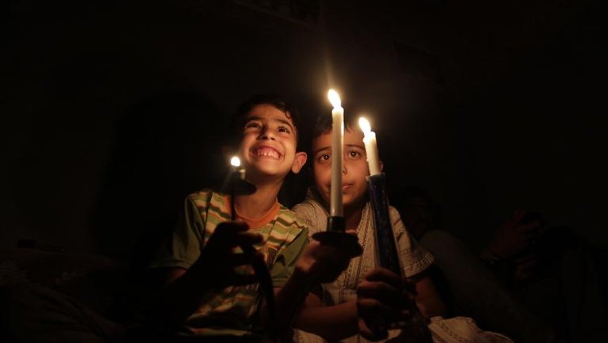 Des enfants yéménites s'éclairent à la bougie dans une maison de Sanaa, au 2e jour d'une coupure générale d'électricité à travers le pays, le 14 avril 2015