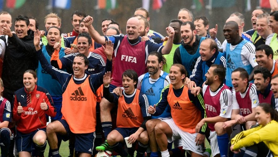 Le nouveau président de la Fifa Gianni Infantino (c) entouré d'anciens joueurs et de joueuses après un match au siège de la Fédération internationale à Zurich, le 28 février 2016