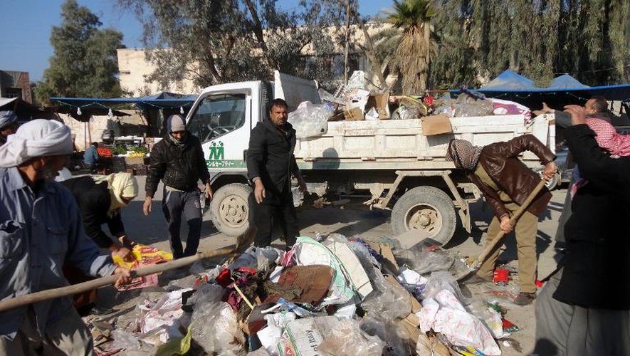 Des personnes nettoient un tas d'ordures dans le centre de Fallouja, le 8 janvier 2014