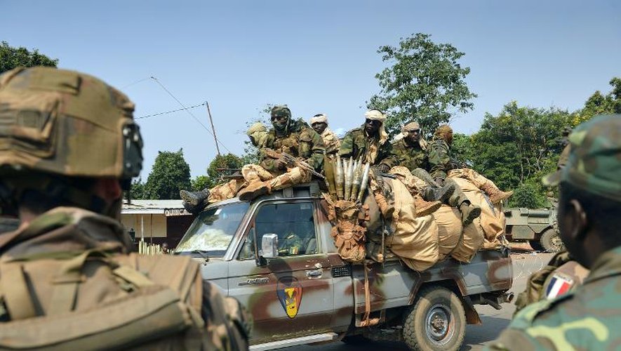 Des soldats tchadiens de la force africaine Misca passent à côté des soldats français de l'opération Sangaris, le 10 janvier 2014 à Bangui