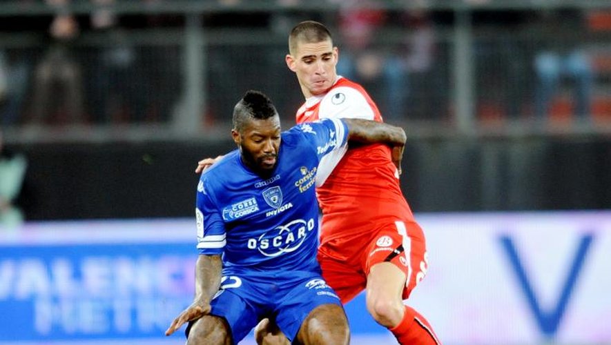 L'attaquant de Bastia Djibril Cissé (g) à la lutte avec le défenseur de Valenciennes Carl Medjani lors du match de Ligue 1 entre les deux équipes, le 11 janvier 2014 au Stade du Hainaut