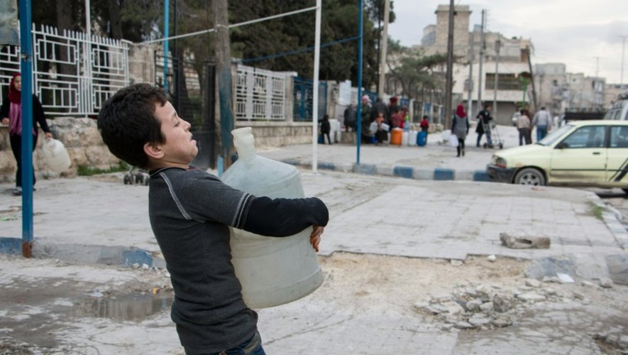 Un jeune syrien porte un container d'eau, le 23 février 2016 dans le quartier rebelle d'al-Maghayer, à Alep
