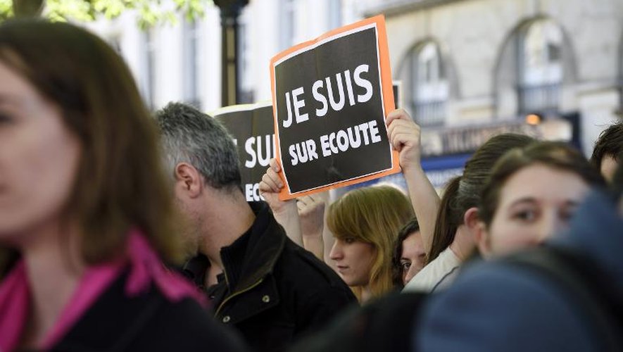 Des manifestants portent des pancartes "Je suis sur écoute" pastichant le slogan "Je suis Charlie" pour protester contre le projet de loi sur le renseignement, le 13 avril 2015 à Paris