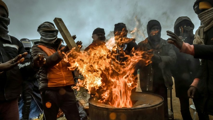 Des migrants se réchauffent autour d'un feu dans la "jungle", le 1er mars 2016 à Calais