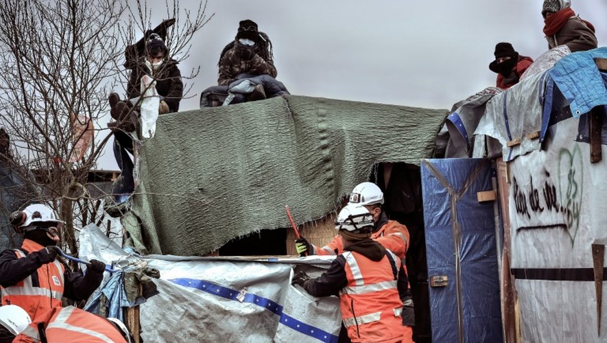 Des migrants observent le démentèlement de leur campement dans la "jungle", le 1er mars 2016 à Calais