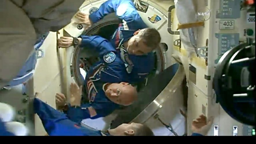 Le cosmonaute russe Mikhaïl Kornienko (haut) et l'astronaute américain Scott Kelly (bas) pénètrent dans la Station spatiale internationale (ISS), le 28 mars 2015 (capture d'écran NASA TV)