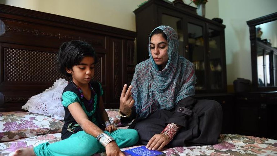 Saima Tanveer donne des cours à sa fille dans leur maison de Peshawar, le 10 avril 2015