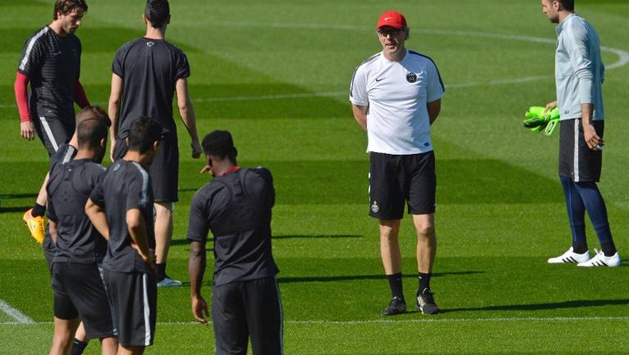 L'entraîneur du PSG Laurent Blanc (avec une casquette) donne des directives à ses joueurs à l'entraînement au Camp des Loges, le 14 avril 2015
