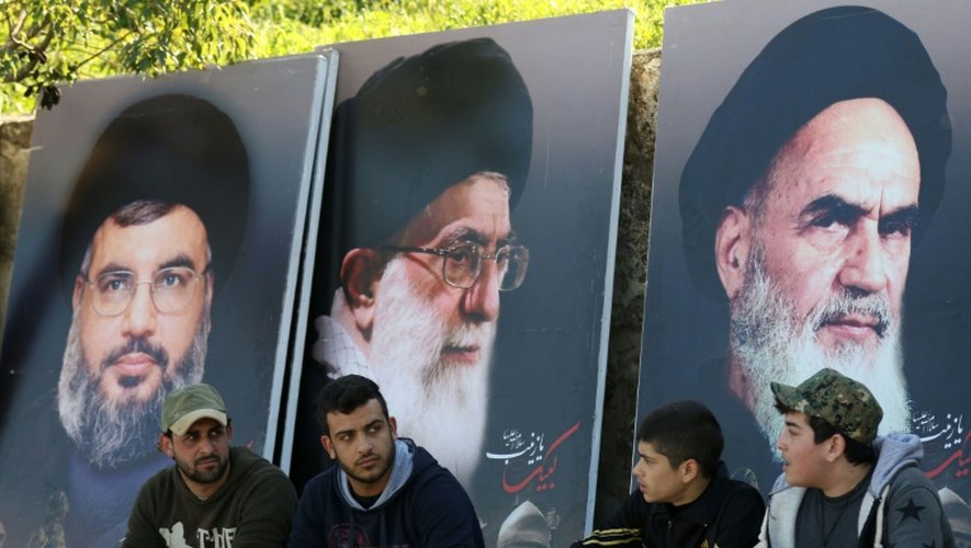 Des Libanais assis devant des portraits d'Hassan Nasrallah, chef du Hezbollah (à gauche), du fondateur de la République d'Iran, l'Ayatollah Khomeini (droite), et du Guide suprême iranien, Ali Khamenei (centre), à Kfour, au Liban, le 1er mars 2016