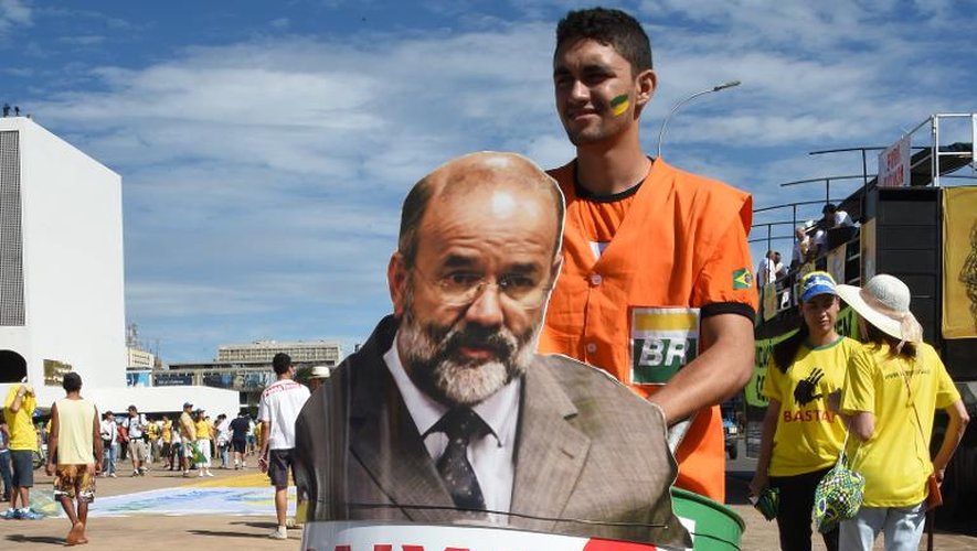 Un homme montre le portrait du trésorier du Parti des Travailleurs, Joao Vaccari, lors d'une manifestation hostile au parti au pouvoir, le 12 avril 2015 à Brazilia