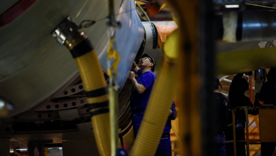 Un employé chinois travaille sur le fuselage d'un avion sur le sol de montage de l'usine d'Airbus de Tianjin le 1er mars 2016