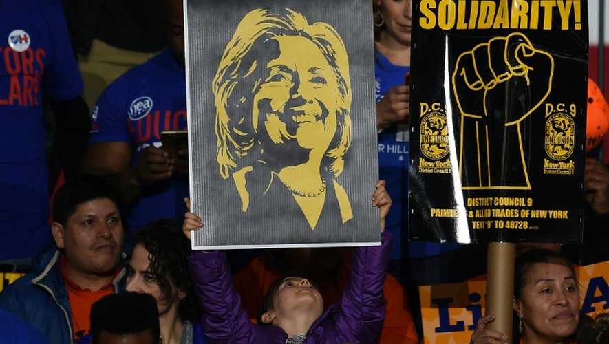 Une femme tient un poster d'Hillary Clinton, le 2 mars 2016 à New York