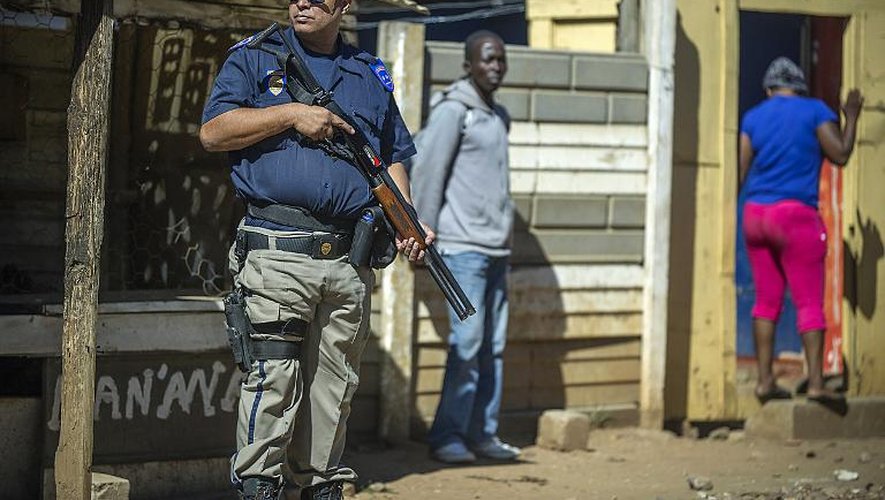 Un policier sud-africain monte la garde devant un magasin tenu par un étranger, dans le village de Primrose près de Johannesburg, le 16 avril 2015