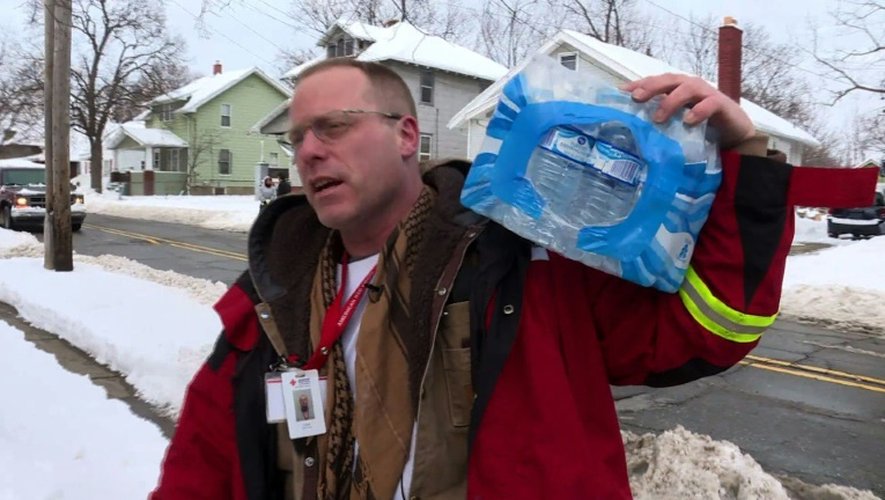 Un volontaire de la Croix rouge américaine livre des packs de bouteilles d'eau aux habitants de Flint