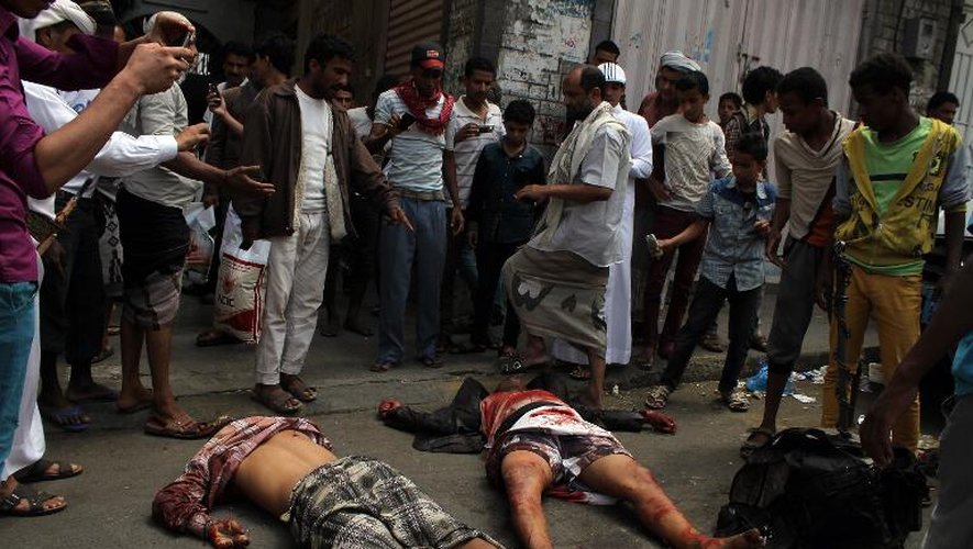 La foule entoure le 17 avril 2015 à Taëz, dans le sud-est du Yémen, les corps de deux rebelles Houthis tués lors d'affrontements avec des milices loyales au président Abd Rabbo Mansour Hadi