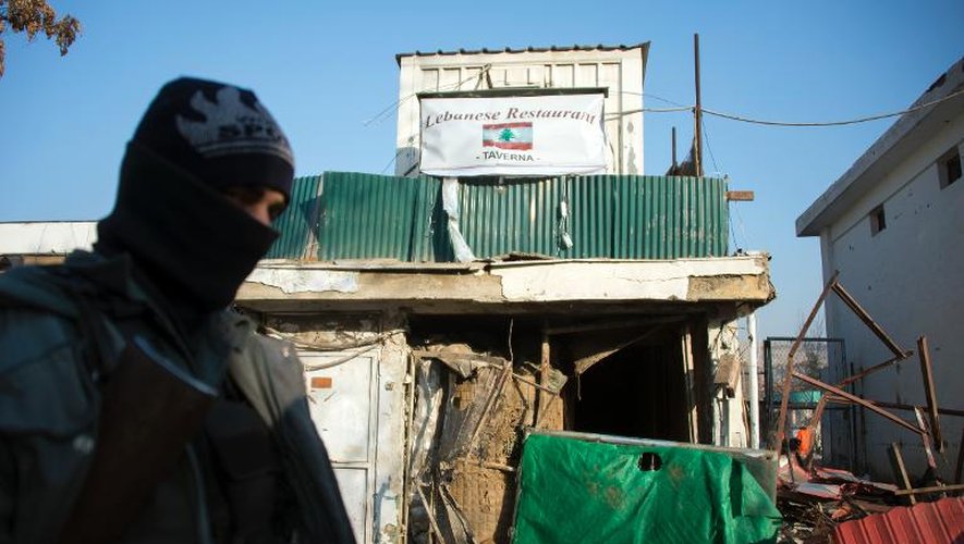 Un policier afghan devant le restaurant libanais cible d'une attaque meurtrière des talibans, le 18 janvier 2014 à Kaboul