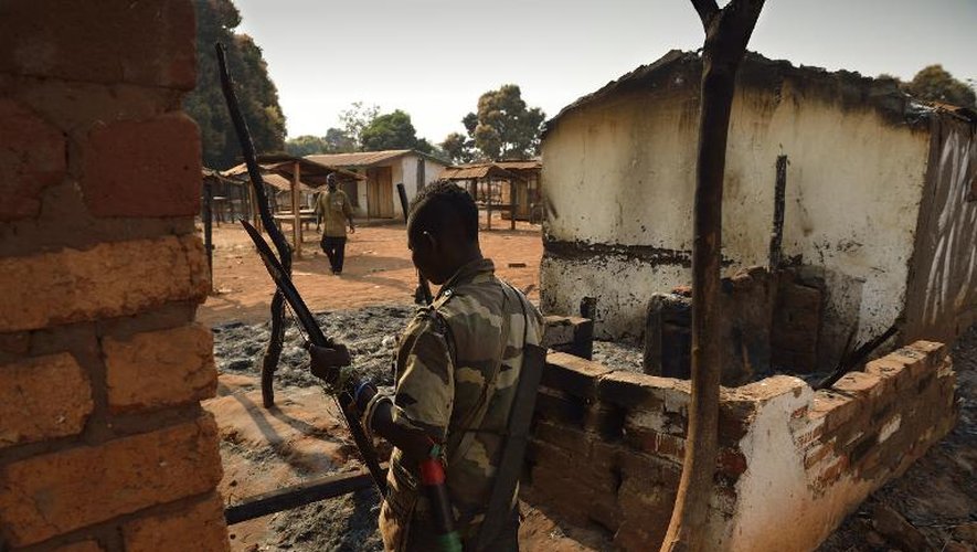 Un combattanat "anti-Balaka" au milieu de  maisons incendiées par des membres de la Séléka à Bougoura, à 60 km au nord de Bangui, le 19 janvier 2014