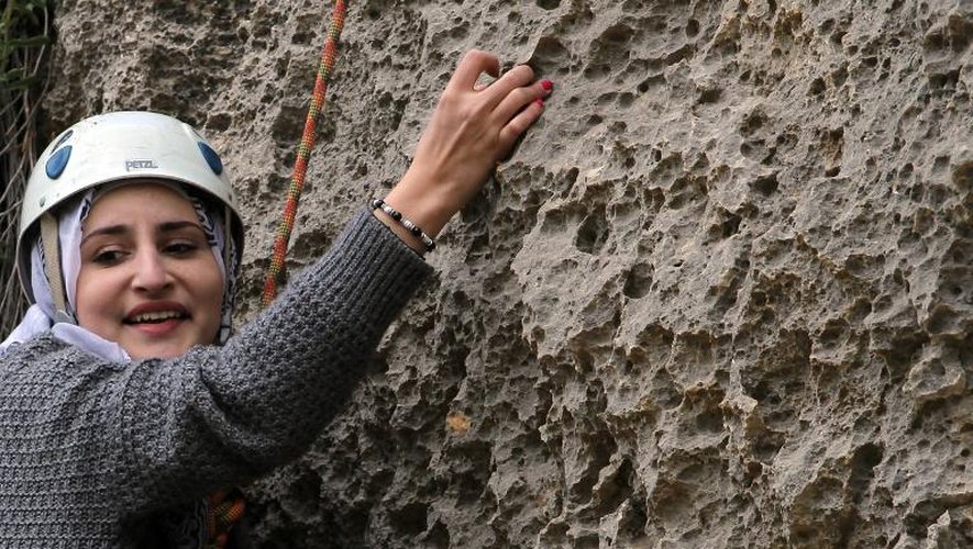 Une jeune Palestinienne escalade un rocher le 15 avril 2015 dans le 
village de Yabroud en Cisjordannie