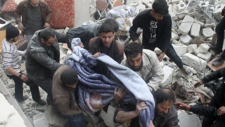 Le corps d'une victime est extrait des décombres d'un immeuble détruit par des raids de l'armée syrienne, le 19 janvier 2014 à Alep