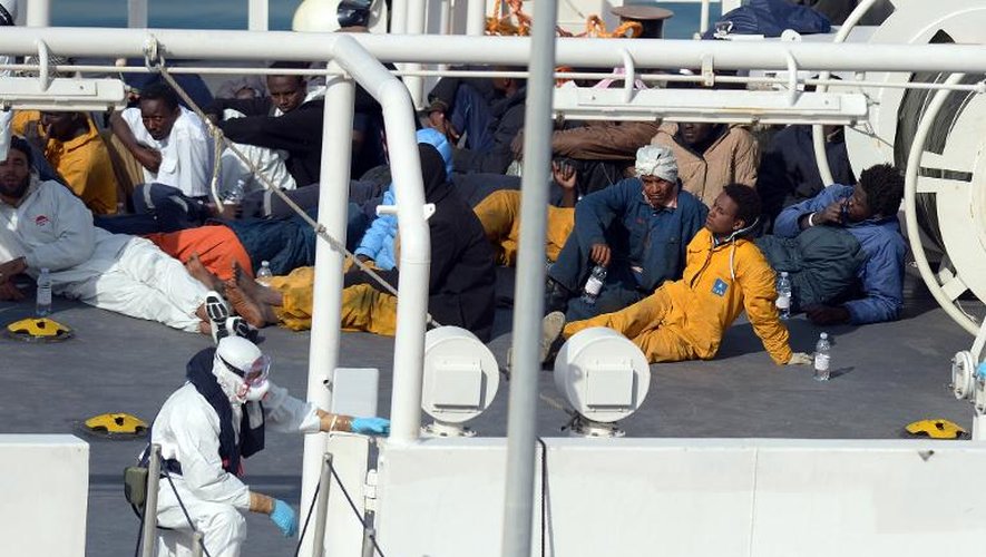 Les survivants du naufrage d'un chalutier au large de la Libye sont installés sur le pont d'un garde-côtes italien, amarré le 20 avril 2015 dans le port de La Valette, à Malte