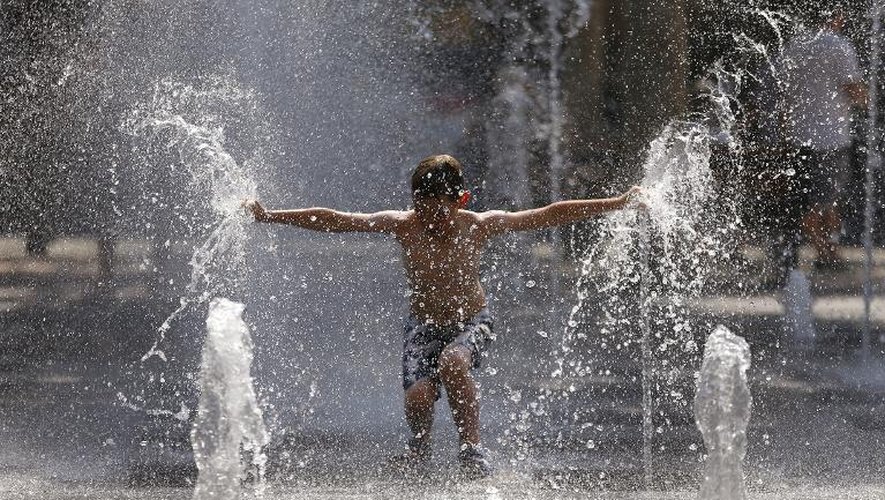Un enfant se rafraichit dans une fontaine le 22 juillet 2013, à Antibes, France