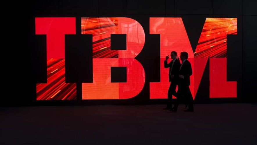 Des personnes passent devant le logo d'IBM