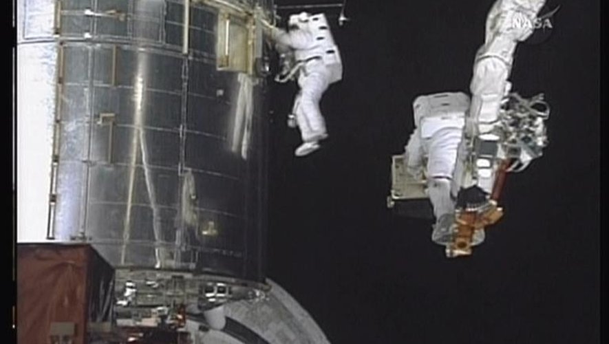 Capture d'image d'une vidéo de la Nasa montrant les astronautes John Grunsfeld (d) et Drew Feustel en train de réaliser des travaux de réparation et de modernisation du télescope spatial Hubble, le 18 mai 2009