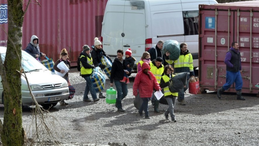 Des migrants accompagnés par des membres d'associations arrivent au camp de Grand-Synthe dans le nord de la France, le 7 mars 2016