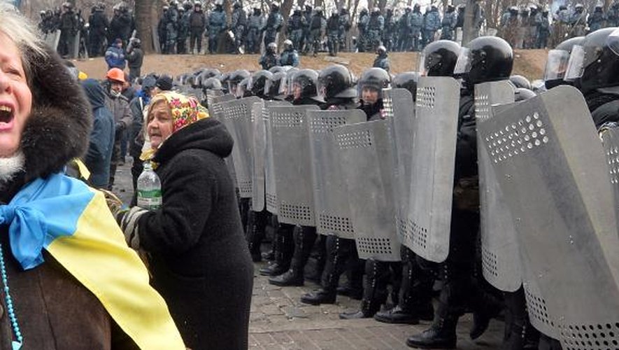 Une militante de l'opposition ukrainienne fait face le 21 janvier 2014 aux forces de l'ordre devant le Parlement à Kiev