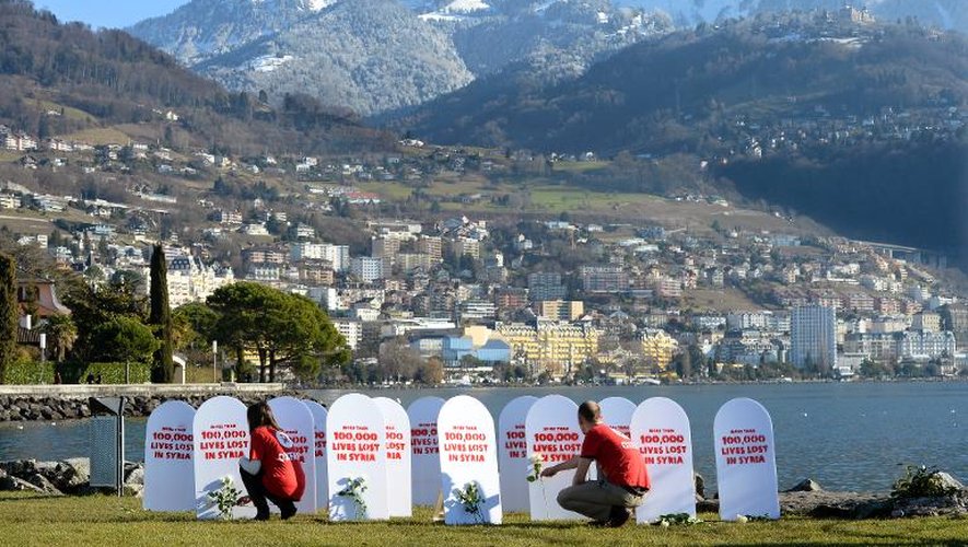 Des militants de l'ONG Oxfam placent des roses dans un faux cimetière pour manifester contre la guerre en Syrie en marge de la Conférence Genève II à Montreux, le 22 janvier 2014