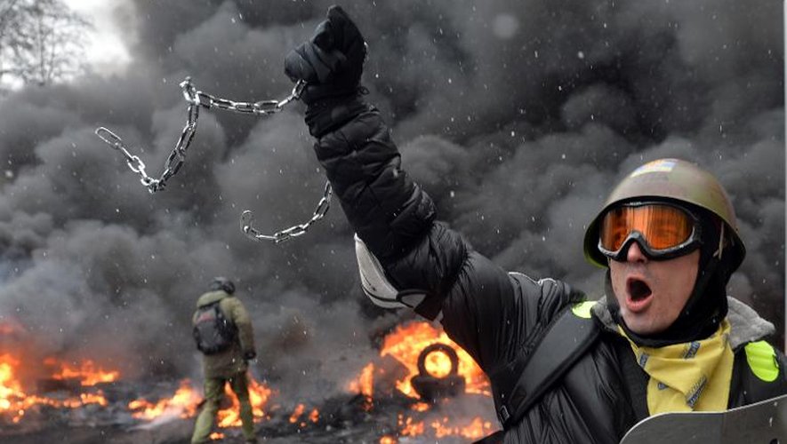- Un manifestant tenant une chaîne et un bouclier de police durant des manifestations à Kiev le 22 janvier 2014