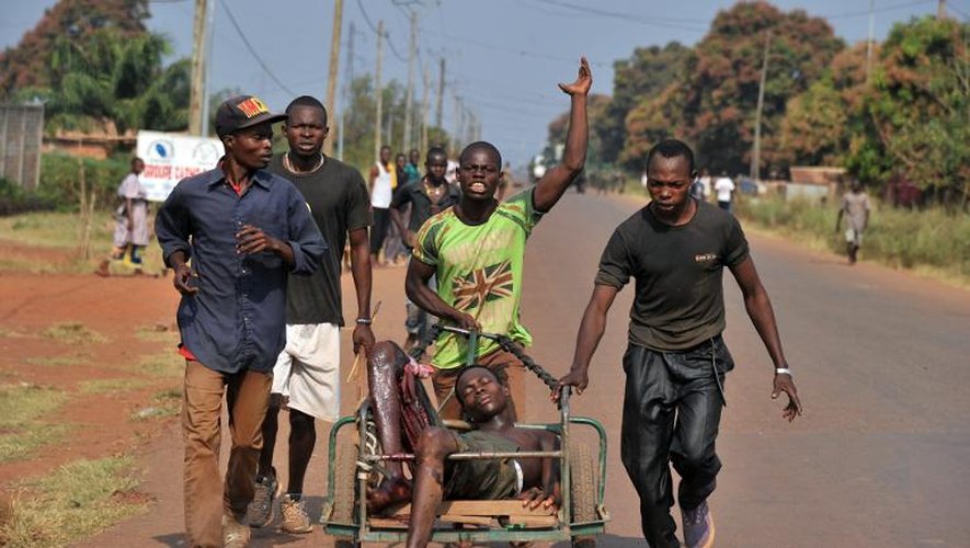 Des jeunes transportent un homme blessé dans une brouette dans le quartier PK-13 à la sortie nord de Bangui, après une attaque des milices chrétiennes anti balaka