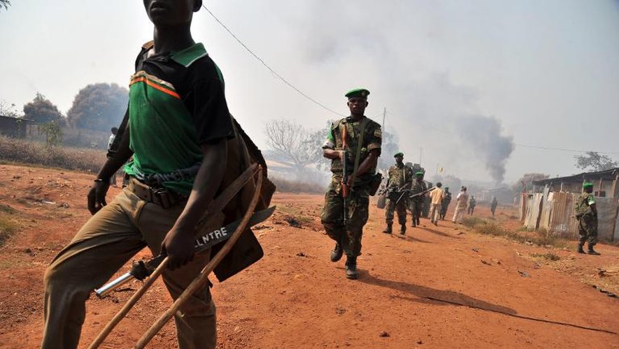 Des soldats rwandais de la mission Misca en Centrafrique suivent un homme qu'ils ont arrêté, soupçonné d'appartenir aux milices anti balaka, transportant une épée, et un arc dans le quartier PK-13 de Bangui le 22 janvier 2014
