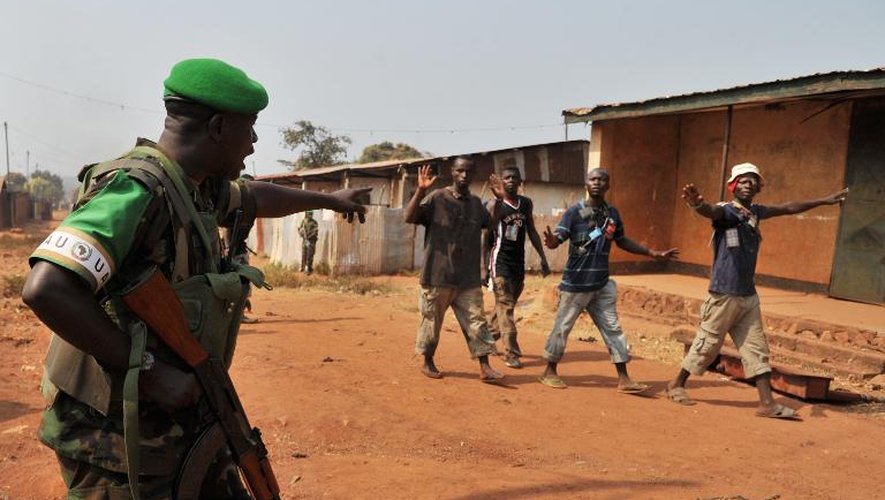 Un soldat rwandais appartenant à la mission MISCA fait un geste en direction d'un groupe de passants alors qu'il patrouille le quartier Pk13 au nord de Bangui après une attaque des milices chrétiennes anti-Balaka
-