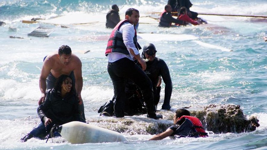 Des hommes viennent en aide à des migrants après un naufrage au large de Rhodes en Grèce, le 20 avril 2015