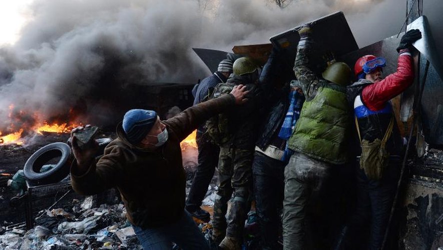 Un manifestant ukrainien se prépare à jeter un pavé en direction de la police anti-émeutes, le 23 janvier 2014 dans le centre de Kiev