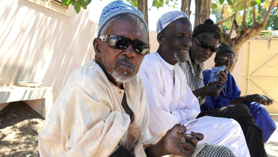 Quatre personnes âgées, guéries de la lèpre, sur un banc de Mballing au Sénégal, le 20 janvier 2014