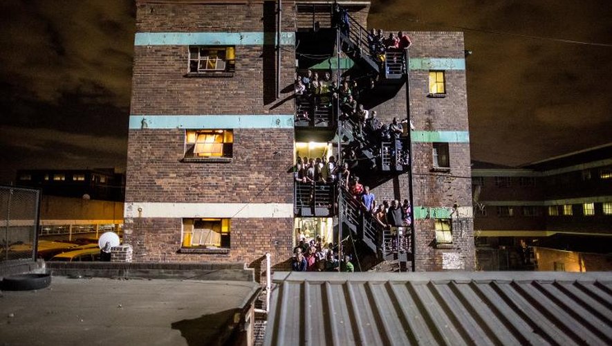 Des habitants d'un foyer de travailleurs rassemblés dans les escaliers lors d'un raid nocturne de la police sud-africaine épaulée par l'armée le 21 avril 2015 à Jeppestown