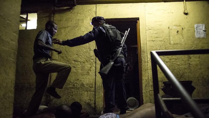 Des Sud-africains allongés face contre terre lors d'un raid nocturne de la police sud-africaine épaulée par l'armée le 21 avril 2015 un foyer hébergeant des travailleurs à Jeppestown