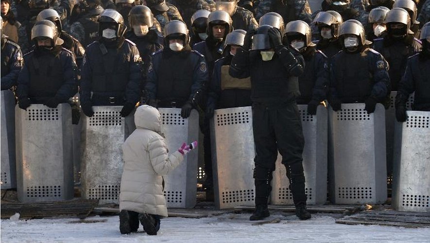 Une manifestante agenouillée devant les forces de l'ordre le 24 janvier 2014 à Kiev