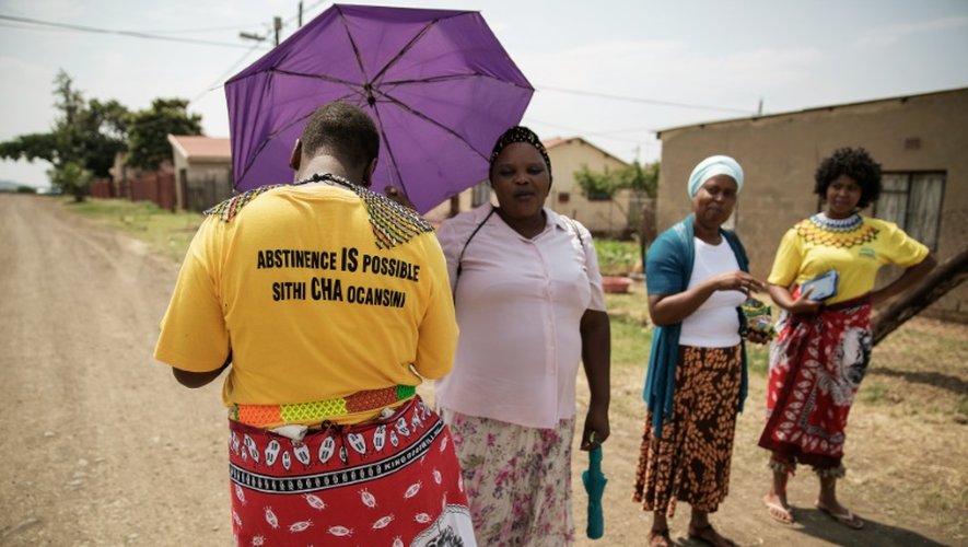 Bongiwe Sithole (g) et Thubelihle Dlodlo (d), bénéficiaires de la controversée "Bourse d'études pour les vierges", se promènent à Ezakheni, près de Ladysmith en Afrique du Sud, accompagnées de leurs matrones, le 16 février 2016