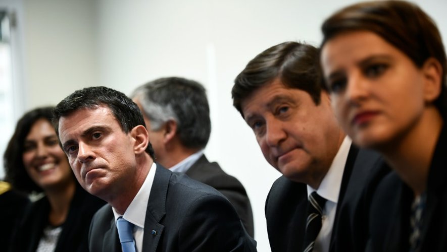 Le Premier ministre Manuel Valls (g), et les ministres du Travail Myriam El Khomri (derrière), de la Jeunesse et des Sports Patrick Kanner (d) et de l'Éducation Najat-Vallaud Belkacem, à la Mission Locale des Mureux, près de Paris, le 26 octobre 2015