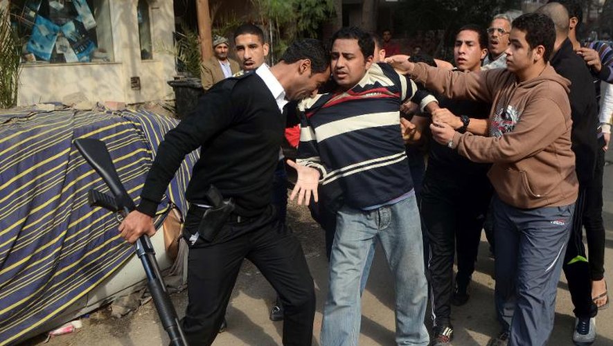 Un policier arrête un partisan des Frères musulmans le 25 janvier 2014 au Caire