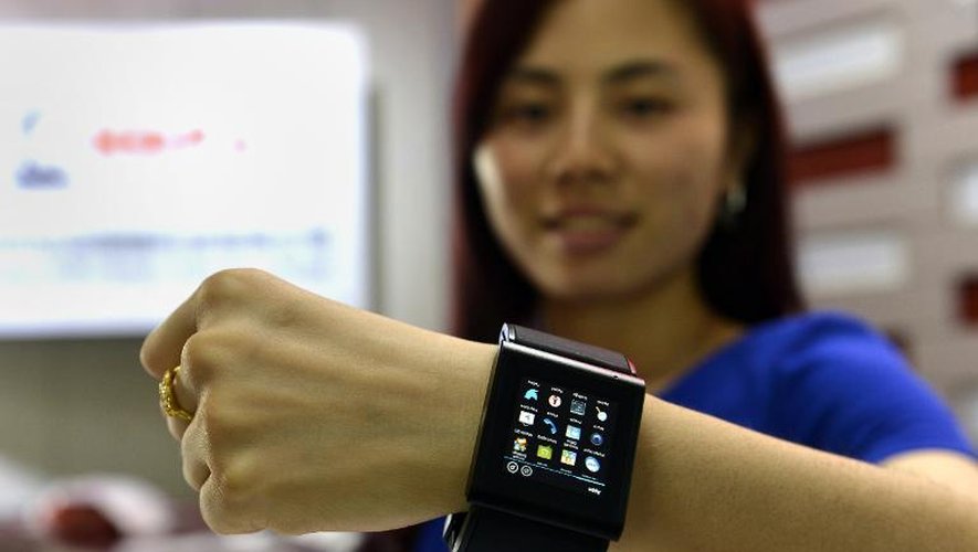 Une femme fait la promotion d'une montre concurrente à l'Apple Watch, le 22 avril 2015 dans une usine de Shenzhen, dans le sud de la Chine
