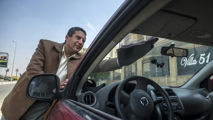 Ahmed Mahmoud, chauffeur Uber, nettoie son véhicule, le 23 février 2016 au Caire