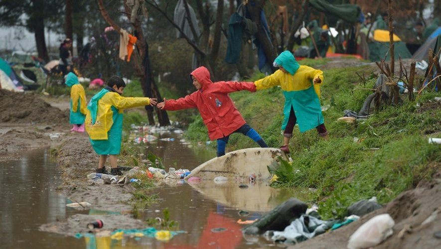 Souvent trempés, les plus chanceux portant de longs imperméables plastiques distribués par les ONG, des groupes d'enfants pataugent dans les champs inondés