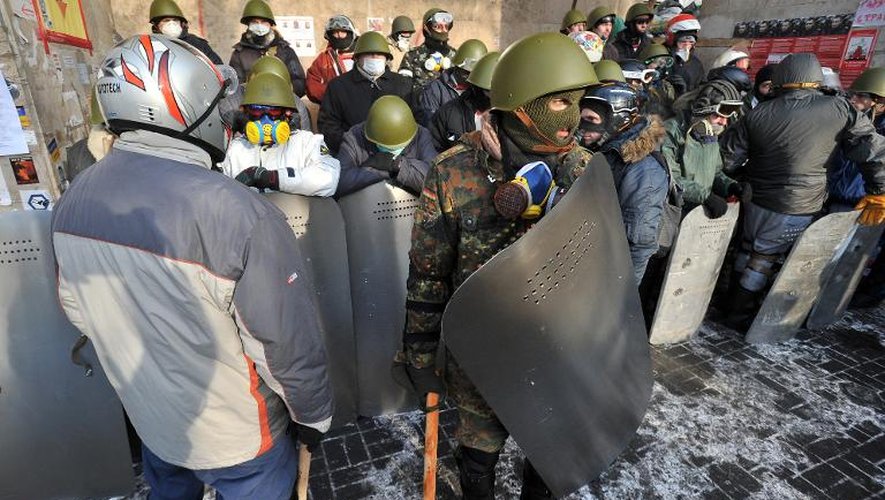 Des manifestants portant casques, cagoules, masques à gaz, masques de ski et boucliers, le 25 janvier 2014 place de l'Indépendance, à Kiev
