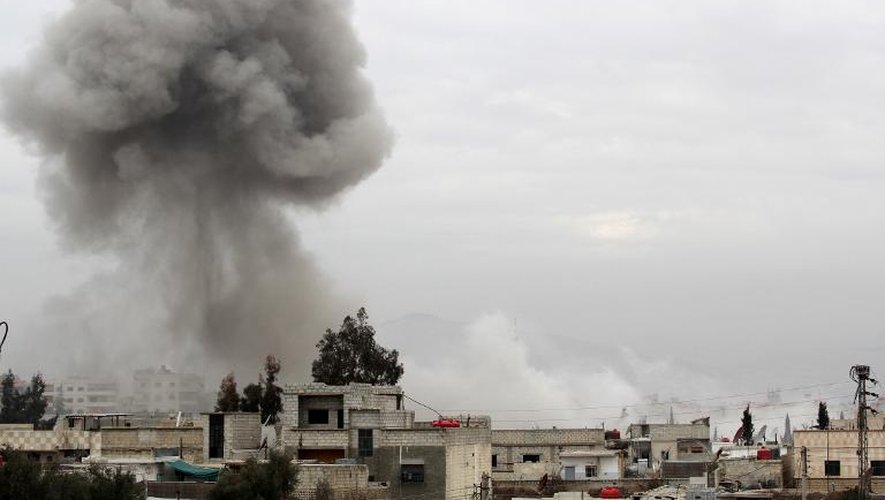 De la fumée au-dessus d'immeubles après une attaque aérienne de l'armée syrienne, le 25 janvier 2014 à Daraya, au sud-ouest de Damas