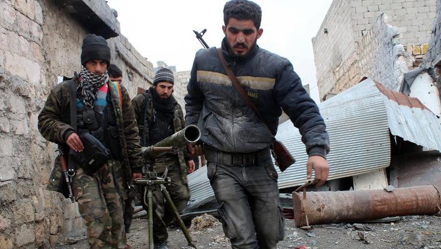 Des rebelles syriens transportent un lance-roquettes lors de combats contre l'armée, le 27 janvier 2014 à Alep